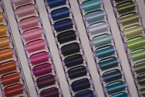 Разноцветные нити, расположенные подряд в портной — стоковое фото