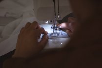 Крупный план женских рук, шьющих ткани на швейной машинке — стоковое фото
