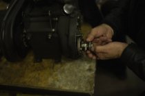 Mecánico de reparación de motor de moto en el garaje - foto de stock