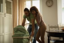 Les parents regardent leur bébé dans un chalutier à la maison — Photo de stock