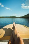 Низкая часть человека отдыхает на лодке в озере — стоковое фото