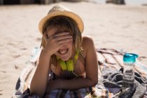 Девочка-подросток закрывает глаза, отдыхая на пляже в солнечный день — стоковое фото