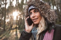 Молодая женщина разговаривает по мобильному телефону в лесу . — стоковое фото