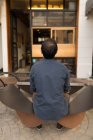 Visão traseira do homem de camisa azul sentado no café pavimento — Fotografia de Stock