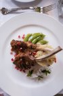 Primo piano delle costolette di maiale servite sul piatto con contorno sul tavolo — Foto stock