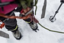 Gros plan d'une montagnarde debout avec harnais et corde dans une région enneigée — Photo de stock