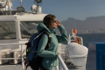 Жінка з рюкзаком, що стоїть на круїзному кораблі — стокове фото