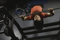 Handicapped man doing chest workout on bench press with barbell in gym — Stock Photo