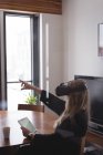 Жіночий виконавчий за допомогою віртуальної реальності гарнітура з цифровий планшетний в офісі — стокове фото