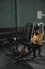 Інвалідний чоловік перевіряє мобільний телефон на лавці прес в спортзалі — стокове фото