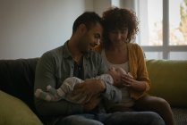 Eltern halten ihr Baby zu Hause im Wohnzimmer — Stockfoto