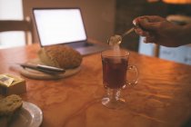Frau fügt Teelöffel Zucker zu ihrer Teetasse zu Hause hinzu — Stockfoto