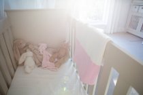 Wooden cradle with soft toys at home — Stock Photo