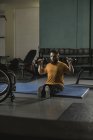 Handicapped man exercising with dumbbells in gym — Stock Photo