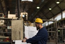Aufmerksame Techniker prüfen Maschine in der Metallindustrie — Stockfoto
