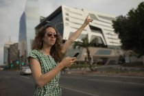 Bella donna in visita per la corsa con un telefono cellulare in mano — Foto stock