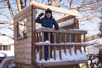 Портрет милого мальчика, играющего со снегом на детской площадке зимой — стоковое фото