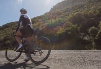 Жінка-велосипедистка відпочиває по дорозі в сонячний день — стокове фото