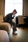 Geschäftsfrau telefoniert mit Handy, während sie Schuhe im Hotelzimmer trägt — Stockfoto