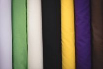 Gros plan divers tissus de couleur disposés en rangée dans le magasin de tailleur — Photo de stock