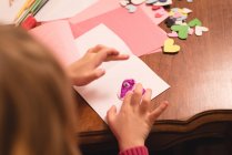 Девушка готовит украшение формы сердца дома — стоковое фото