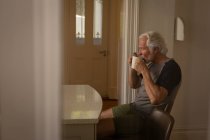 Активних старшим людина вдома за кавою — стокове фото