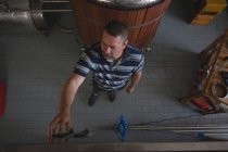 Vue à angle élevé du travailleur masculin surveillant un manomètre du réservoir de stockage — Photo de stock