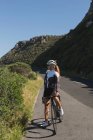 Motociclista donna in piedi con mountain bike su strada in una giornata di sole — Foto stock