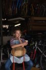 Задумчивая женщина-механик пьет кофе в мастерской — стоковое фото