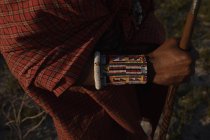 Mittelteil eines Massai-Mannes in traditioneller Kleidung, der mit Stock steht — Stockfoto