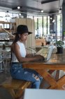 Menina adolescente atenta usando laptop no restaurante — Fotografia de Stock