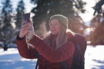 Жінка бере селфі з мобільним телефоном в сонячний день — стокове фото