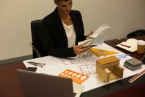 Reife Geschäftsfrau überprüft Dokument am Schreibtisch im Büro — Stockfoto