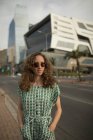 Красивая женщина в солнечных очках стоит на обочине дороги — стоковое фото