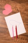 Close-up of heart shape craft and colored pencil on wooden floor — Stock Photo