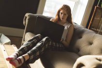 Жінка використовує ноутбук у вітальні вдома — стокове фото