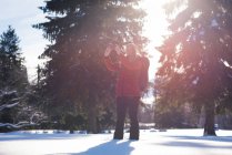 Жінка натискає фотографію на смартфон взимку — стокове фото