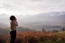Woman taking picture with digital camera at countryside — Stock Photo