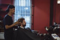 Uomo che si fa tagliare i capelli con la forbice dal barbiere — Foto stock