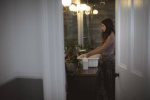 Femme se lave les mains dans l'évier à la salle de bain — Photo de stock