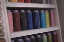 Fios multicoloridos dispostos em linha na loja de alfaiate — Fotografia de Stock