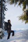 Seitenansicht einer Frau, die durch verschneite Landschaft geht — Stockfoto