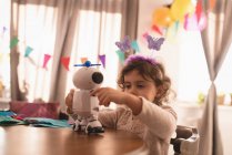 Little girl playing with robot toy in living room at home. — Stock Photo