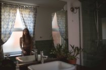 Nachdenkliche Frau sitzt auf Fensterbank im Badezimmer — Stockfoto