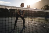 Junge Frau übt Tennis auf Tennisplatz — Stockfoto