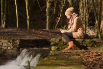Frau benutzte Handy im Wald — Stockfoto