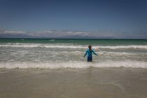 Vue arrière de la fille jouant en mer à la plage — Photo de stock