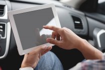 Крупный план мужских рук с помощью цифрового планшета в автомобиле — стоковое фото