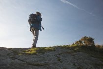 Rear view of male hiker standing with backpack at countryside — Stock Photo