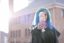 Stylish woman holding an ice cream in city street — Stock Photo
